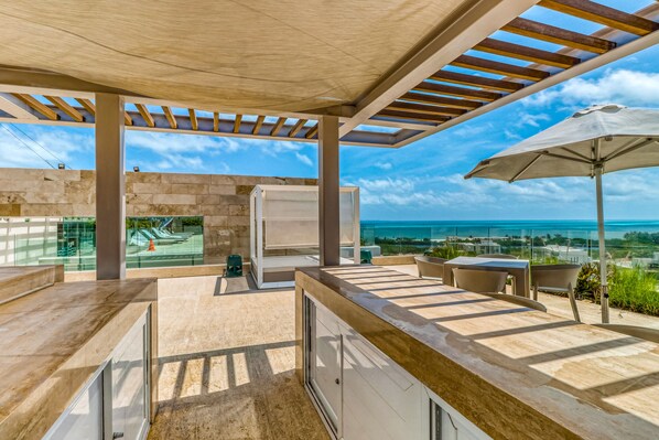 Outdoor dining - Ocean view condo w/ luxury pool access, central AC, WiFi & shared rooftop/dock (Cancun)