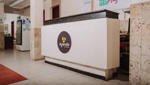Un mostrador de recepción con un logotipo, un refrigerador y una pared con un letrero que dice 'Hotel Playa Ma'.