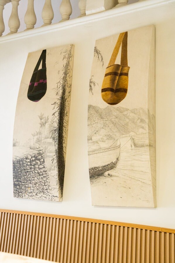 Dos obras de arte montadas en la pared que muestran una bolsa y un bote.
