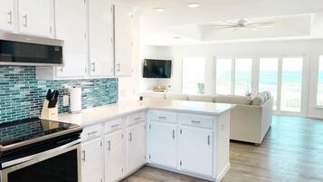 Una cocina moderna con armarios blancos, una estufa negra y un salpicadero de azulejos azules.