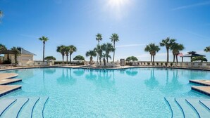 A clear blue pool with steps leading into it, surrounded by palm trees and lounge chairs. - Beach House - Gulf Front!  Right on the Beach! - WIFI - Sleeps 10- Pools (Gulf shores)