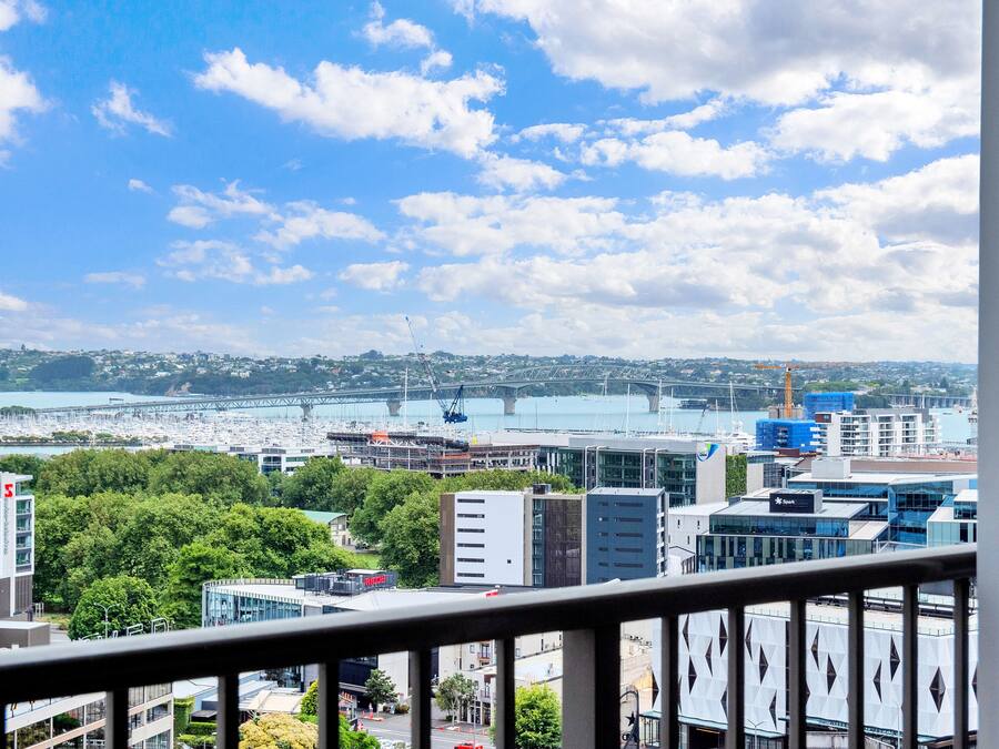 Paisagem urbana com edifícios modernos, uma ponte e uma orla.