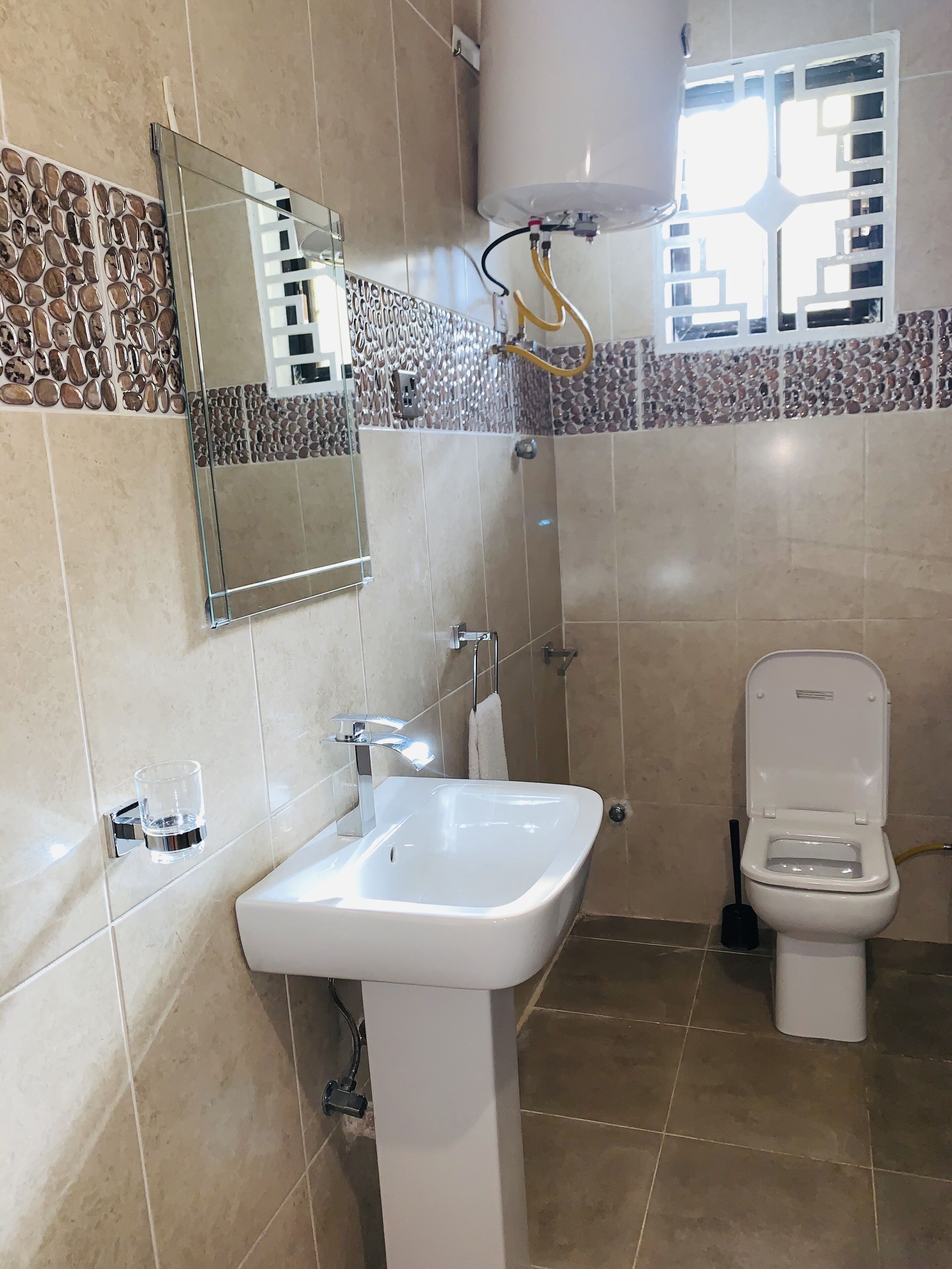 A bathroom with a white sink, a toilet, and a mirror.