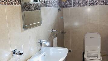 A bathroom with a white sink, a toilet, and a mirror.