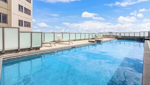 Una piscina con cielo azzurro e nuvole sullo sfondo.