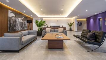 A modern living room with a sofa, a coffee table, and a lounge chair.