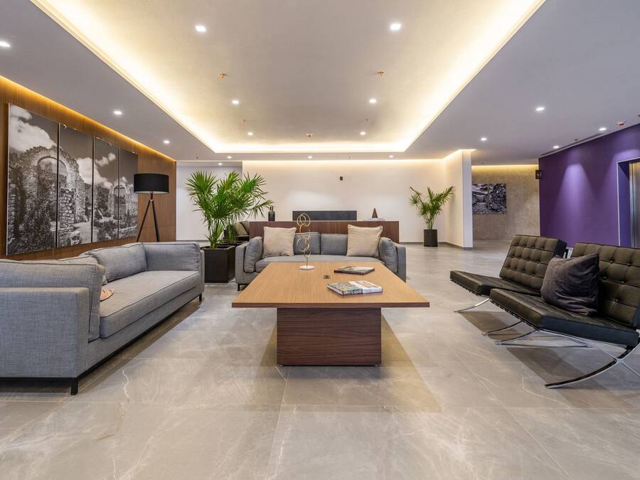 A modern living room with a sofa, a coffee table, and a lounge chair.