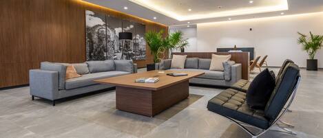 Una sala de estar moderna con un sofá, una mesa de centro y un sillón.