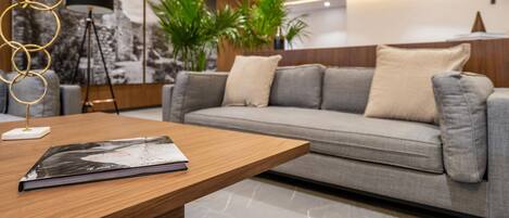 A modern living room with a grey sofa, a wooden coffee table, and a floor lamp.