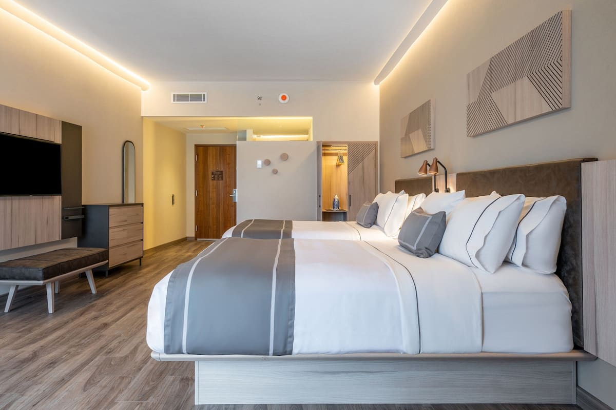 Une chambre d’hôtel moderne, dotée d’un grand lit, d’un bureau et d’une télévision.