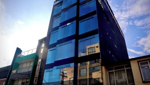 A modern building with reflective glass windows and a mix of architectural styles. - Hotel Wess Bogota (Bogotá)