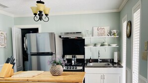 A kitchen with a wooden island, stainless steel appliances, and white cabinetry.