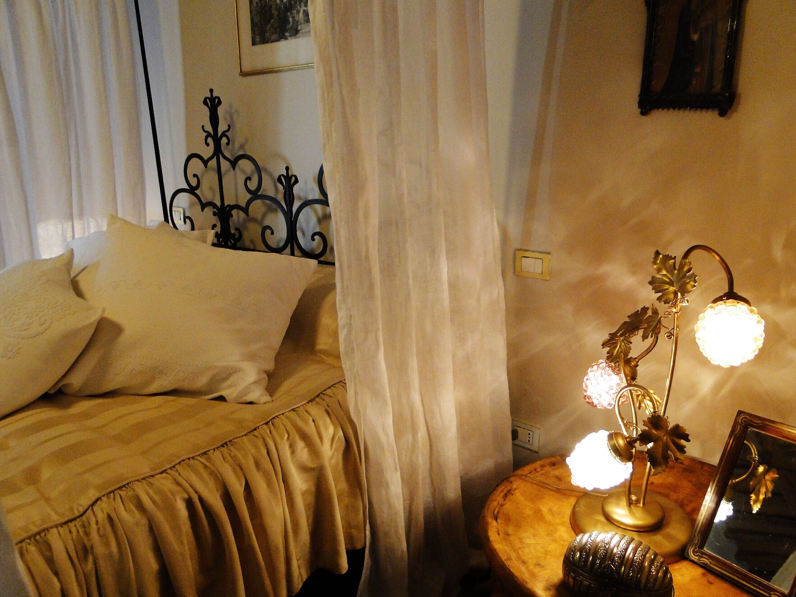 Une chambre à coucher avec un lit, une table de chevet avec une lampe et un miroir.