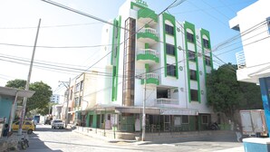 A multi-story building with a green and white facade, balconies, and a sign indicating it is a hotel. - Ayenda 1609 Hotel Arrecife Caribeño (Santa Marta)