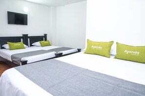 A hotel room with two beds, each with a grey bedspread and green pillows labeled "Ayenda Hotels". - Ayenda 1609 Hotel Arrecife Caribeño (Santa Marta)