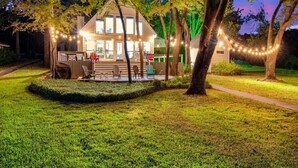 Une maison dotée d’un porche abrité, de guirlandes lumineuses et d’une pelouse bien entretenue.