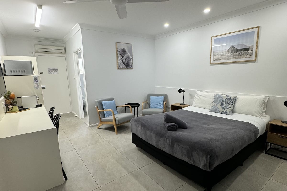 Une chambre moderne avec un grand lit, un bureau et une chaise.
