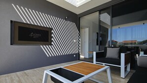 Un interior moderno con un cartel enmarco, un diseño geométrico en la pared y una zona de estar minimalista.