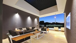 Un área de estar moderna con un conjunto de sofás, una mesa de centro y sillas.