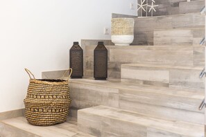 A staircase with a woven basket and two decorative vases.