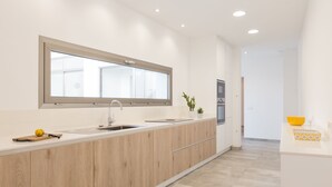 Una cucina moderna con un piano di lavoro in legno, un'ampia finestra e un lavello.