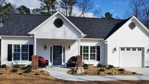 A two-story house with a front porch, a garage, and a driveway.