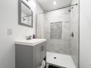 Regadera, toallas, shampoo, papel de baño 
