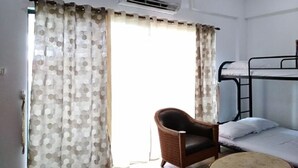 Une chambre avec un lit superposé, une chaise et une table ronde.
