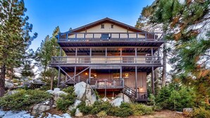 A multi-story wooden cabin with a balcony, surrounded by trees and rocks. - Mv50 Grand Lodge Lake Tahoe With Game Room Hot (Stateline)