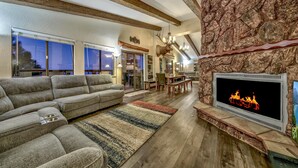 A modern living room with a sectional sofa, a fireplace, and a stone accent wall. - Mv50 Grand Lodge Lake Tahoe With Game Room Hot (Stateline)