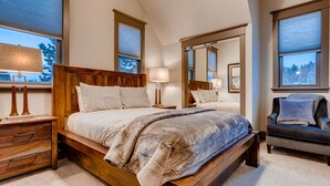 A bedroom with a wooden bed, a nightstand, a dresser, and a chair.