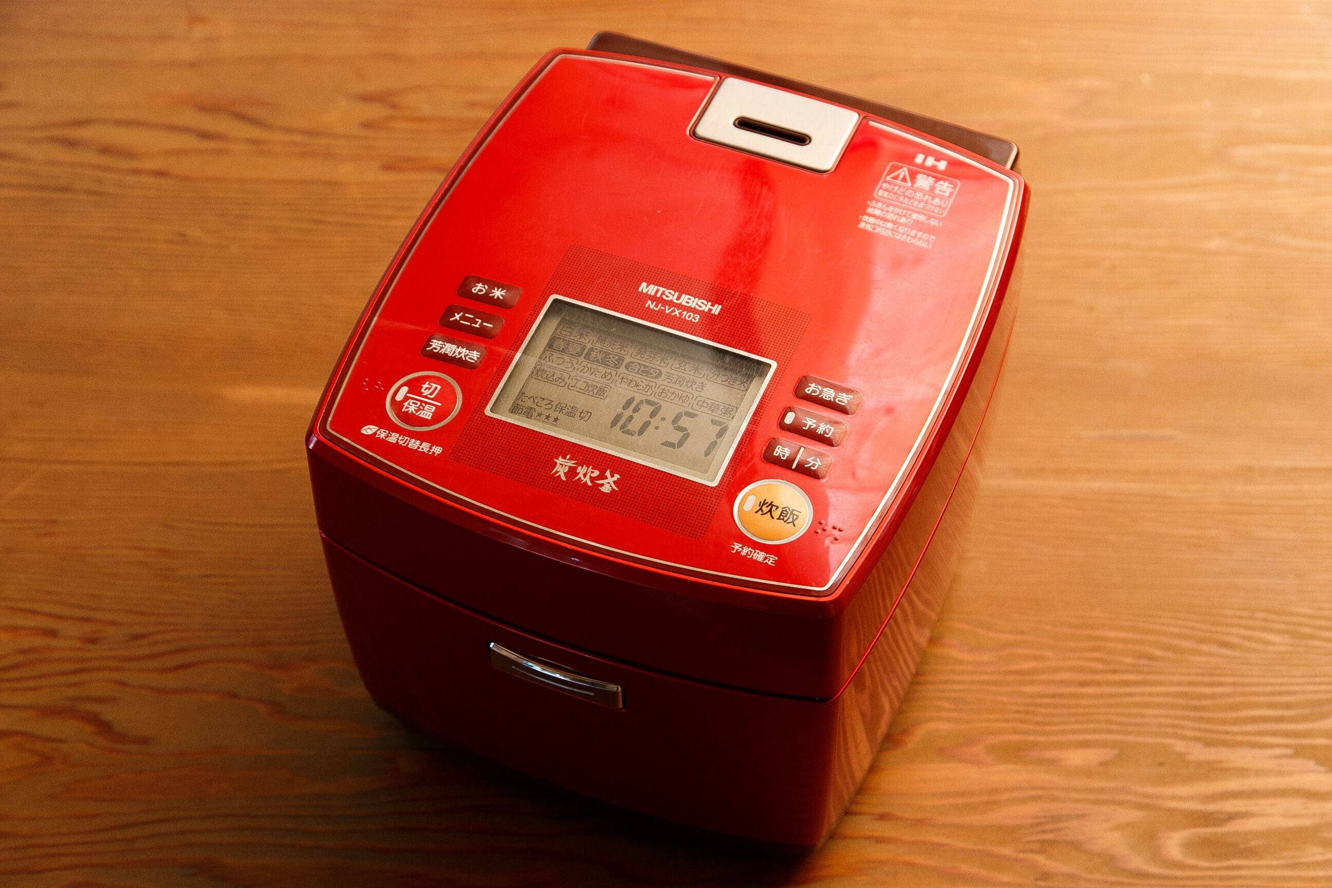 A red microwave oven on a wooden surface.