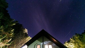 A cabin with a triangular roof, two windows, and a view of the night sky. - Loghouse Seseragi (Tsuru)