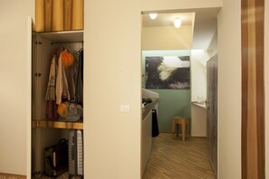 Une cuisine compacte avec un plan de travail en bois, un petit tabouret et un tableau accroché au mur.