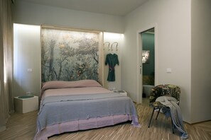 Une chambre à coucher avec un lit, une chaise, un peignoir et un tableau accroché au mur.