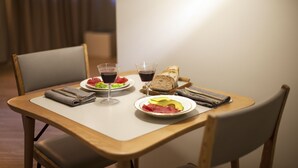 A dining table with plates of food, glasses, and a loaf of bread. - SPOTinROME designer apartment and luxury, rome historic district III column (Roma)