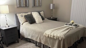 A neatly arranged bedroom with a bed, bedside tables, a lamp, and artwork on the walls. - New Condo near Beautiful Downtown Ann Arbor (Ann Arbor)