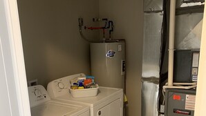 A laundry area with a washing machine, dryer, and a water heater. - New Condo near Beautiful Downtown Ann Arbor (Ann Arbor)