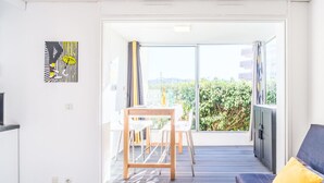 Un appartement moderne doté d’un balcon, d’un coin repas et d’un canapé.