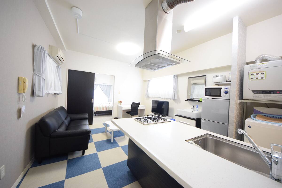 Een compacte keuken met een centraal eiland, een ingebouwde kookplaat en een magnetron.