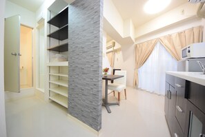 Una cocina moderna con armarios grises, una encimera blanca y una zona de comedor con una mesa y sillas.