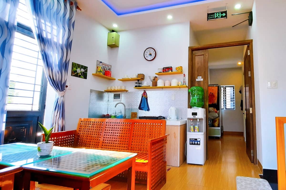 A modern kitchen with wooden shelves, a refrigerator, and a water dispenser.