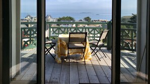 En balkon med havudsigt, en stol og et bord.