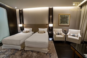Relax in this stylish room with two single beds, a large flat-screen TV, and a cozy seating area.