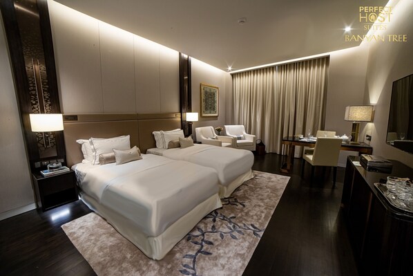 Relax in a spacious room with a large bed, separate seating area, and desk, offering a comfortable retreat with a view.