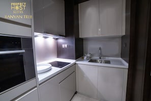Enjoy a convenient kitchen with oven, stovetop, and sink, perfect for preparing a meal.
