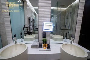 Experience the sleek design of this bathroom, featuring two oval-shaped sinks and a large mirror.