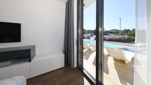 A modern hotel room with a large sliding glass door leading to a pool area. - Villa Lea -  Home4You (Kraj)