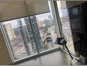 Enjoy city views from the large window, featuring a cityscape of modern high-rise buildings.