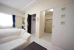 Relax in a serene space with a comfortable sofa, wooden side table, and large mirror.
